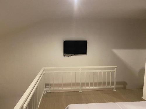 a flat screen tv on a wall in a bedroom at Odadi Guesthouse in Dalung