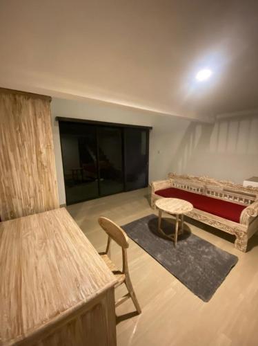 a room with a bed and a couch and a table at Odadi Guesthouse in Dalung