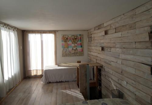 a bedroom with a wooden accent wall and a bed at Puro Deporte entrenamiento y hospedaje in Necochea