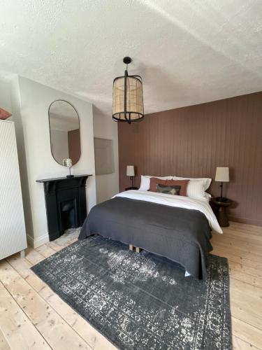 a bedroom with a large bed and a black rug at The Village House in Malahide