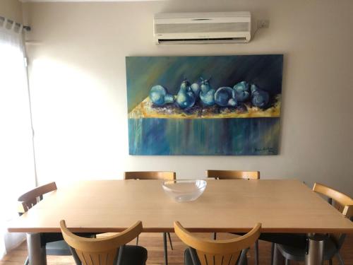 una mesa de comedor con una pintura en la pared en Departamento PARA 6 personas EN SALTA! Amplio y luminoso! en Salta