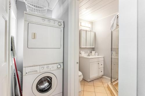 una lavanderia bianca con lavatrice e asciugatrice di Sea Palm Cottage a Ilexhurst