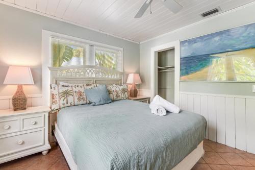 una camera da letto con un letto, due lampade e una finestra di Sea Palm Cottage a Ilexhurst
