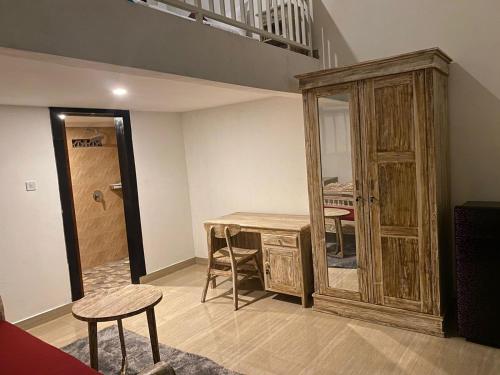 a room with a table and a wooden cabinet at Odadi Guesthouse in Dalung