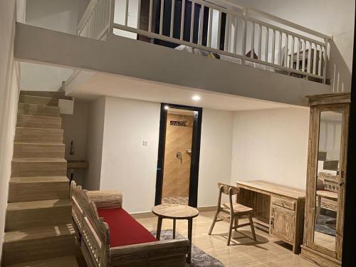 a living room with a staircase and a table and chairs at Odadi Guesthouse in Dalung
