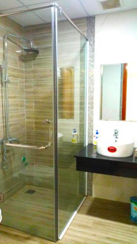 a bathroom with a glass shower and a sink at Sea Star Hotel Quy Nhon in Quy Nhon