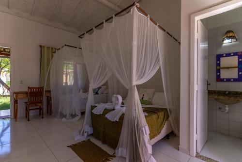 1 dormitorio con 1 cama con dosel en Pousada Recanto Trancoso, en Trancoso