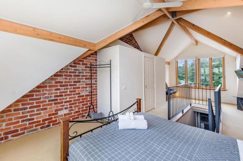 a attic room with a bed and a brick wall at Docks At The Mill in Port Fairy