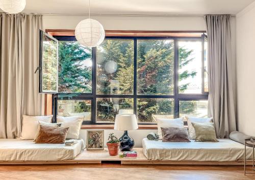 a living room with two beds and a large window at Central Loft with free parking in Porto