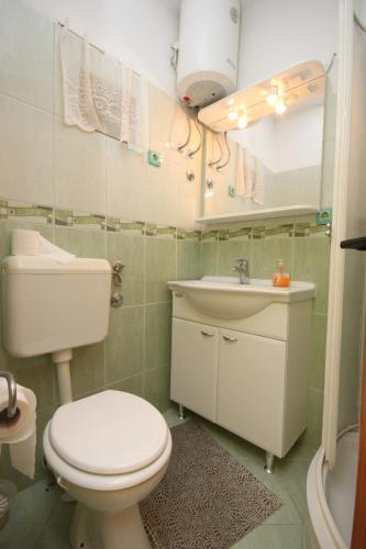 a bathroom with a toilet and a sink at Apartments by the sea Grebastica, Sibenik - 6442 in Bašelovići