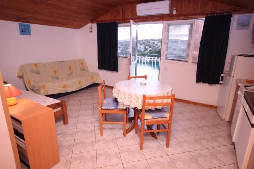 cocina y comedor con mesa y sillas en Apartments by the sea Grebastica, Sibenik - 6442, en Bašelovići