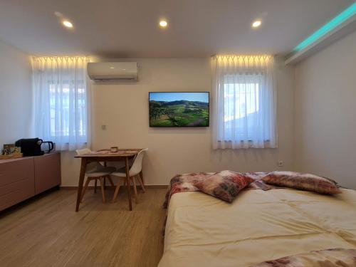 a bedroom with a bed and a table in it at Getaway Pri Kobalu Alisarin, Azure & Apricot in Vipava