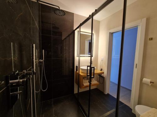 a bathroom with a glass shower with a sink at Restaurant & Apartments Getaway Pri Kobalu in Vipava