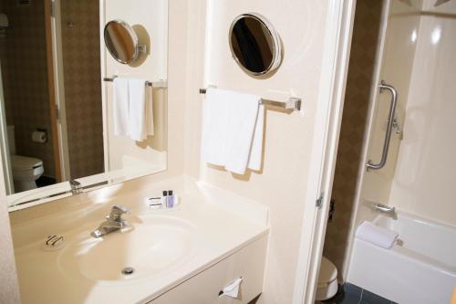 W białej łazience znajduje się umywalka i lustro. w obiekcie iStay Hotel Ciudad Victoria w mieście Ciudad Victoria
