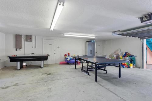 a room with two ping pong tables in it at Tropical luxury pool home by the beach with roof top lounge centrally located on Anna Maria Island in Holmes Beach