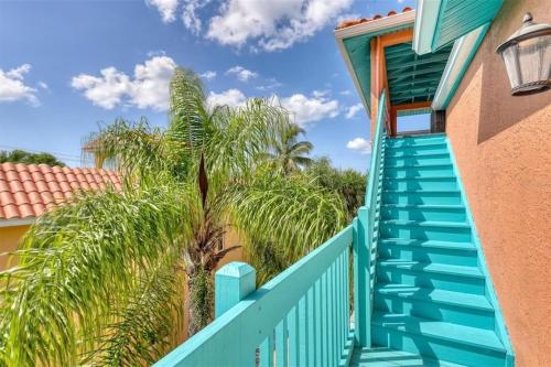a staircase leading up to a house with palm trees at Tropical luxury pool home by the beach with roof top lounge centrally located on Anna Maria Island in Holmes Beach