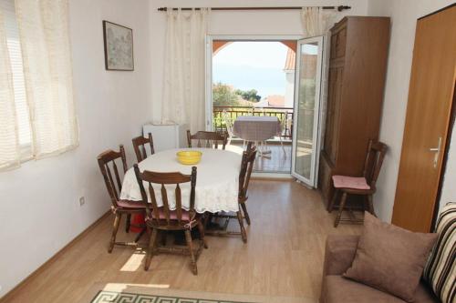 a dining room with a table and chairs and a couch at Apartments with a parking space Gradac, Makarska - 6757 in Gradac