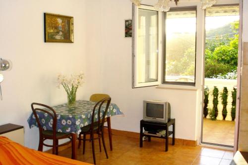 een eetkamer met een tafel en een tv bij Apartments by the sea Podaca, Makarska - 6821 in Podaca