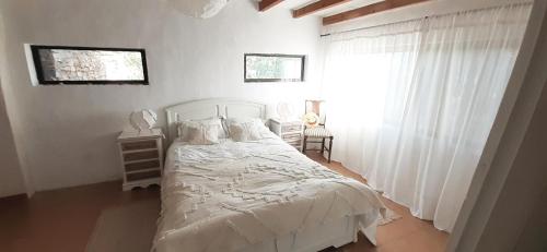 1 dormitorio con cama blanca y ventana en Casa da Abelha- Beehouse, 