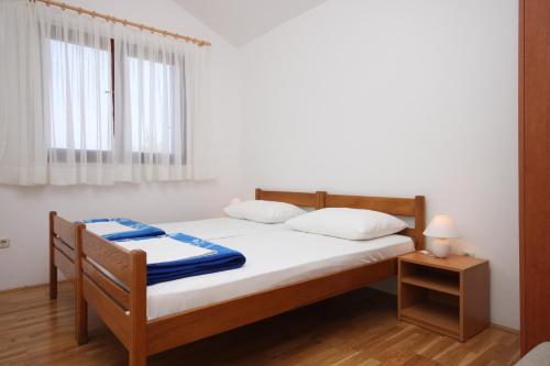 a bedroom with a bed with white sheets and a window at Apartments with a parking space Starigrad, Paklenica - 6613 in Starigrad