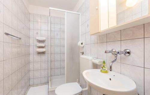 een witte badkamer met een toilet en een wastafel bij Apartments and rooms with parking space Novi Vinodolski - 19963 in Novi Vinodolski