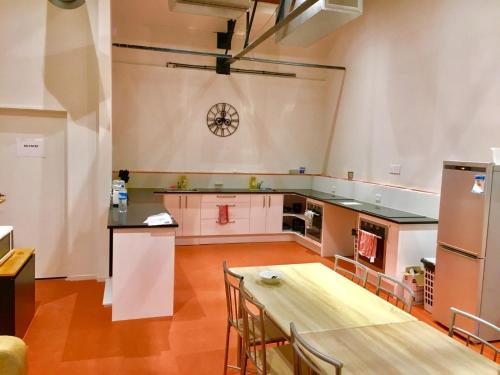 uma grande cozinha com uma mesa de madeira num quarto em Metro Adventurer Backpackers em Auckland
