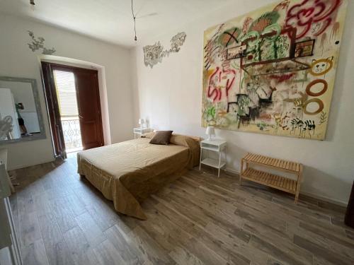 a bedroom with a bed and a painting on the wall at La Rosa del Sulcis in Iglesias