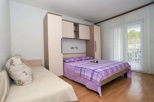 1 dormitorio con cama morada y sofá en Apartments with a parking space Baska Voda, Makarska - 6827, en Baška Voda