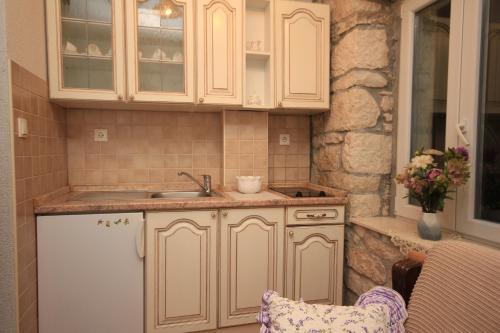 een keuken met witte kasten en een wastafel bij Apartments by the sea Baska Voda, Makarska - 6703 in Baška Voda