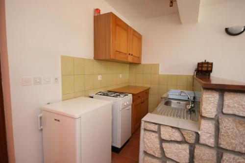 eine kleine Küche mit einem weißen Herd und einem Kühlschrank in der Unterkunft Apartment Mandre 6456b in Mandre