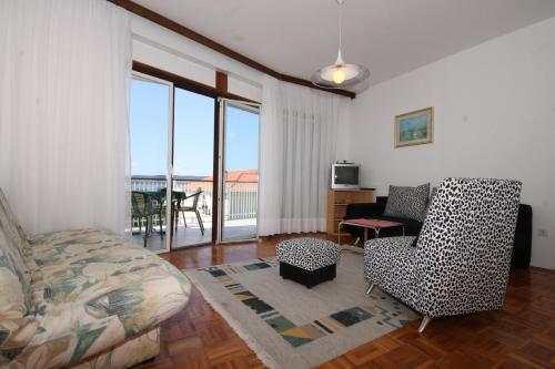 a living room with a couch and a chair at Apartments by the sea Zivogosce - Blato, Makarska - 6797 in Igrane