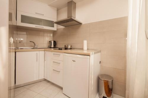 a small kitchen with white cabinets and a sink at Apartments by the sea Zivogosce - Blato, Makarska - 6797 in Igrane