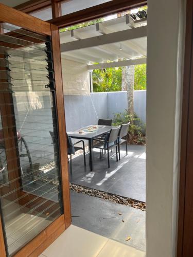 een afgeschermde veranda met een tafel en stoelen bij Beachside Apartment 1 with plunge pool in Port Douglas