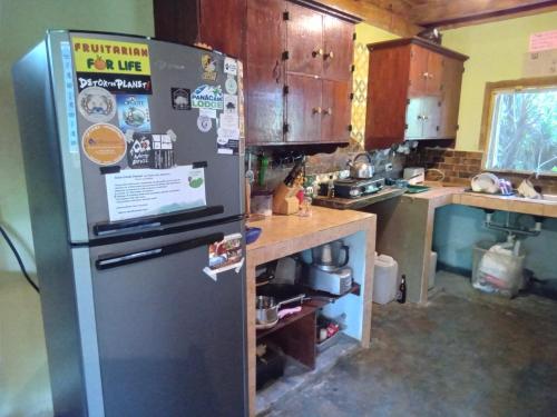 a kitchen with a stainless steel refrigerator and a counter at Hostel Del Lago Yojoa Backpackers in Agua Azul