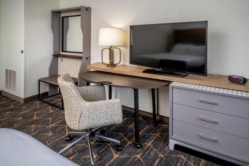 a hotel room with a desk with a tv and a chair at Holiday Inn Hotel & Suites Beckley by IHG in Beckley