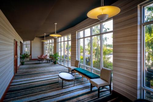 a lobby with windows and a green bench and chairs at Holiday Inn Hotel & Suites Beckley by IHG in Beckley