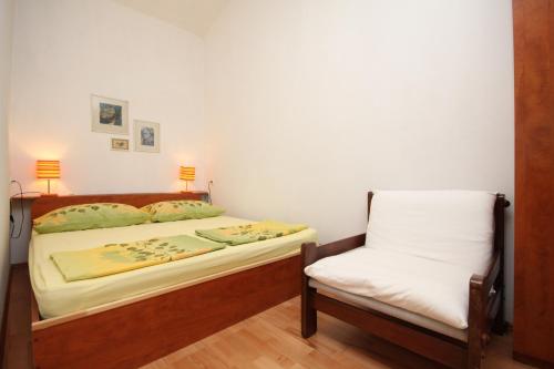 - une chambre avec un lit et une chaise dans l'établissement Apartments with a parking space Povljana, Pag - 6501, à Povljana