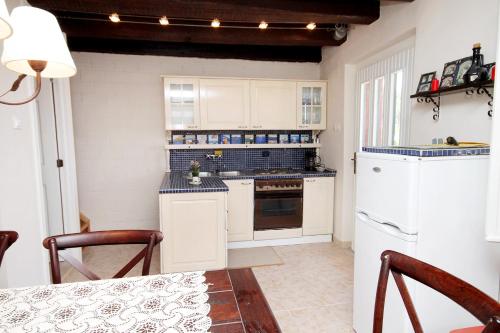 a kitchen with white cabinets and a stove top oven at Holiday house with a parking space Gornji Tucepi - Tomasi, Makarska - 6818 in Tučepi