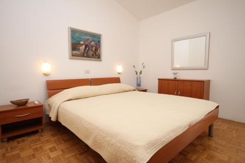 sypialnia z łóżkiem i zdjęciem na ścianie w obiekcie Apartments with a parking space Makarska - 6667 w Makarskiej