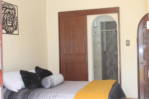 1 dormitorio con 1 cama y puerta de madera en Habitaciones 1 acceso independiente y autonomo Puebla, en Puebla