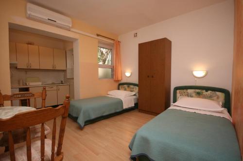 Habitación pequeña con 2 camas y cocina en Apartments by the sea Tucepi, Makarska - 6806 en Tučepi