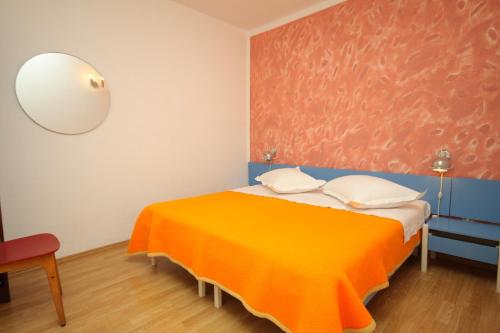 トゥチェピにあるApartment Tucepi 6806bのベッドルーム1室(オレンジ色の毛布付きのベッド1台付)