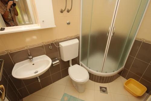 e bagno con servizi igienici, lavandino e doccia. di Apartment Tucepi 6806b a Tučepi