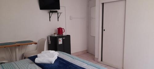 a room with a bed and a tv and a table at Hospedaje de Lidia in Lima