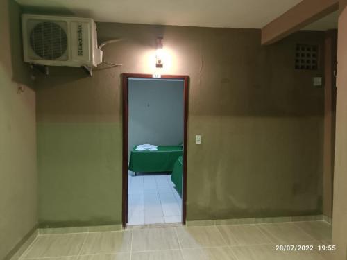 a hallway with a door to a room with a microwave at Pousada Recanto Beach in Camocim