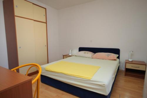 a bedroom with a bed with two pillows on it at Apartments by the sea Baska Voda, Makarska - 6848 in Baška Voda