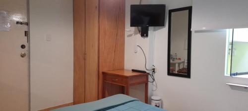 a room with a bed and a television on a wall at Hospedaje de Lidia in Lima