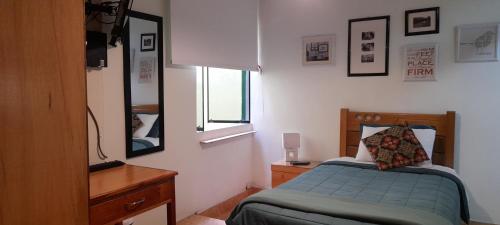 a bedroom with a bed and a dresser and a mirror at Hospedaje de Lidia in Lima