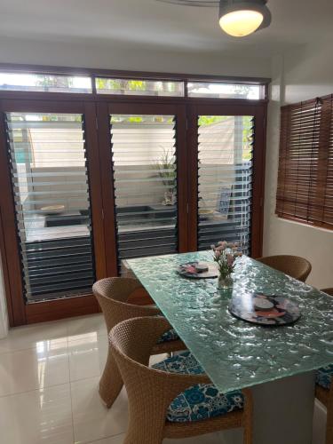 a dining room with a green table and chairs at Beachside Apartment 1 with plunge pool in Port Douglas