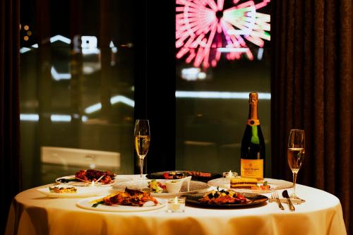 a table with plates of food and a bottle of wine at Garden Terrace Fukuoka in Fukuoka